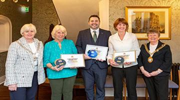 Four award winners with certificates standing with the Lord Mayor